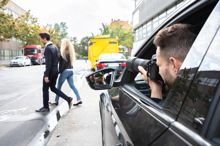 Private Detective Taking Photos Of Man And Woman